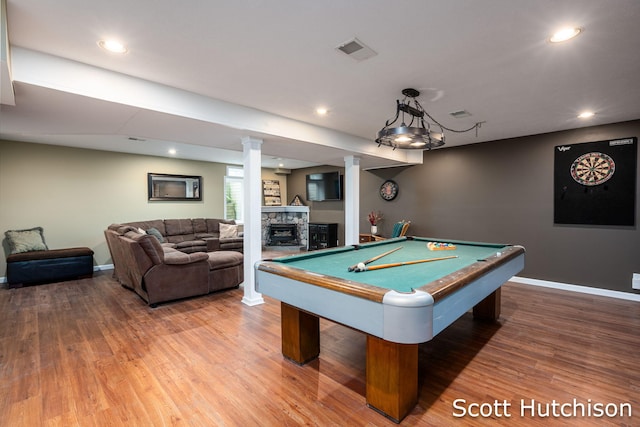 9953 10 Mile Rd NE, Rockford, MI 49341 - playroom featuring wood finished floors, a fireplace, baseboards, recessed lighting, and decorative columns