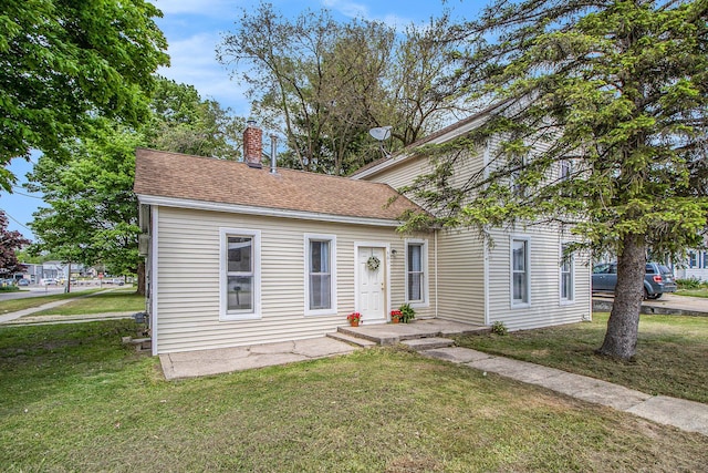 501 E Paw Paw St, Paw Paw, MI 49079 - view of front of home featuring a front lawn, a chimney, and a shingled roof