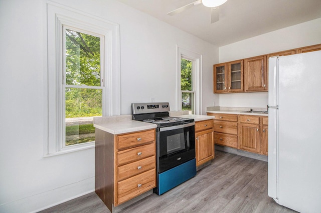 501 E Paw Paw St, Paw Paw, MI 49079 - kitchen featuring freestanding refrigerator, stainless steel electric range oven, brown cabinetry, and light countertops