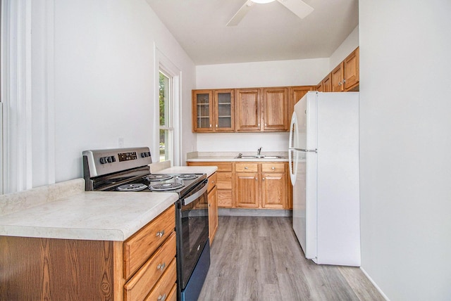 501 E Paw Paw St, Paw Paw, MI 49079 - kitchen featuring freestanding refrigerator, electric stove, a sink, light wood-style floors, and light countertops