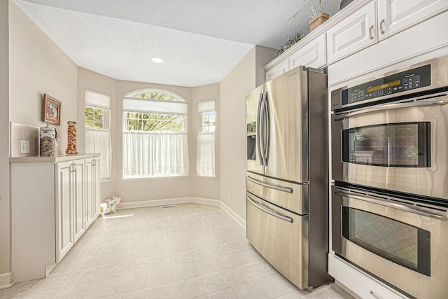 159 Water Lily Way NE, Comstock Park, MI 49321 - kitchen with appliances with stainless steel finishes, white cabinets, baseboards, a textured ceiling, and light countertops