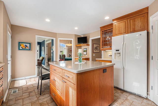 2176 Teal Ct SE, Grand Rapids, MI 49546 - kitchen featuring white refrigerator with ice dispenser, a kitchen island, recessed lighting, glass insert cabinets, and light stone finish flooring