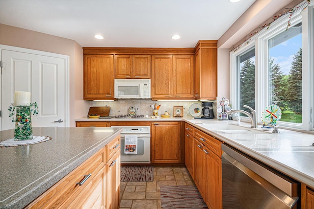 2176 Teal Ct SE, Grand Rapids, MI 49546 - kitchen with white appliances, light stone finish flooring, backsplash, a sink, and recessed lighting