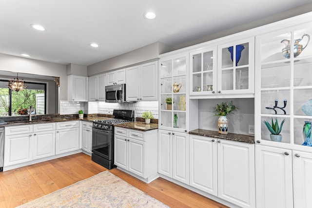 2485 Wildbrook Run Unit 154, Bloomfield Hills, MI 48304 - kitchen with appliances with stainless steel finishes, a sink, white cabinets, glass insert cabinets, and light wood finished floors