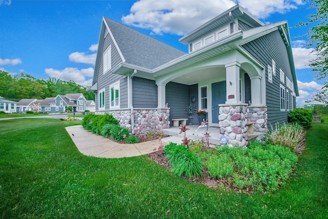 300 Morning Walk Path, Benton Harbor, MI 49022 - view of front of property with covered porch, a front yard, a shingled roof, and stone siding