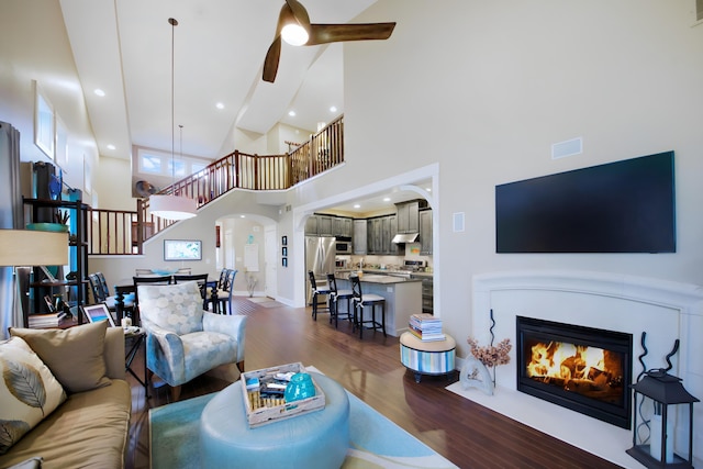 300 Morning Walk Path, Benton Harbor, MI 49022 - living area with stairs, ceiling fan, wood finished floors, arched walkways, and a high ceiling
