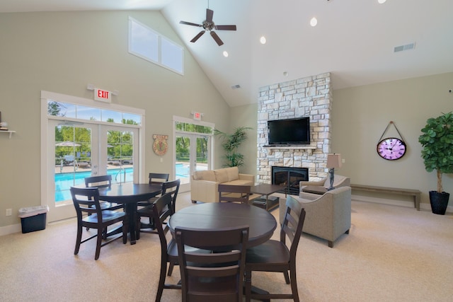 300 Morning Walk Path, Benton Harbor, MI 49022 - dining area featuring french doors, a stone fireplace, ceiling fan, high vaulted ceiling, and light carpet