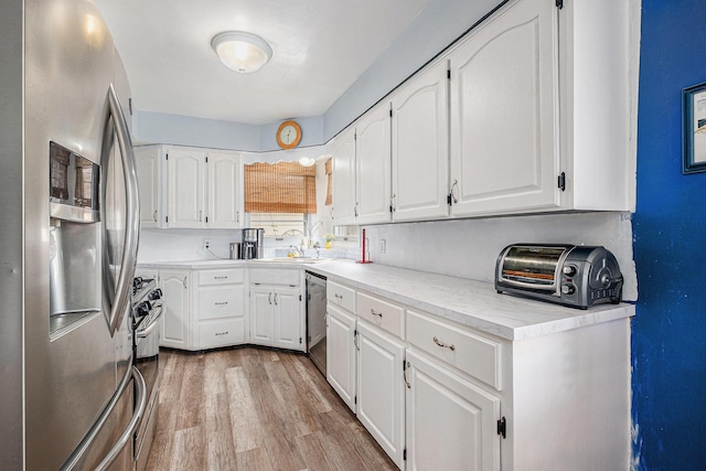 7569 Astronaut Ave, Jenison, MI 49428 - kitchen featuring stainless steel appliances, white cabinets, a sink, wood finished floors, and light countertops