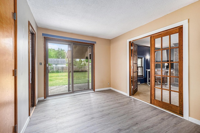 7569 Astronaut Ave, Jenison, MI 49428 - empty room with wood finished floors, a textured ceiling, and baseboards