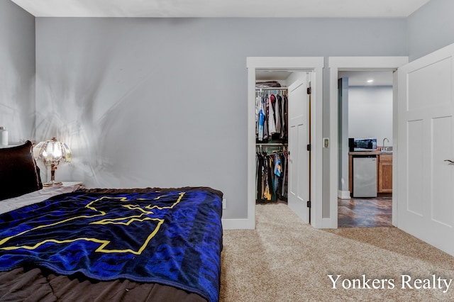 1109 Kenowa Ave SW, Byron Center, MI 49315 - bedroom featuring carpet floors, fridge, a walk in closet, a sink, and a closet