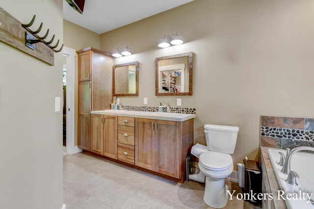 1109 Kenowa Ave SW, Byron Center, MI 49315 - full bath with double vanity, a bath, toilet, tile patterned flooring, and baseboards