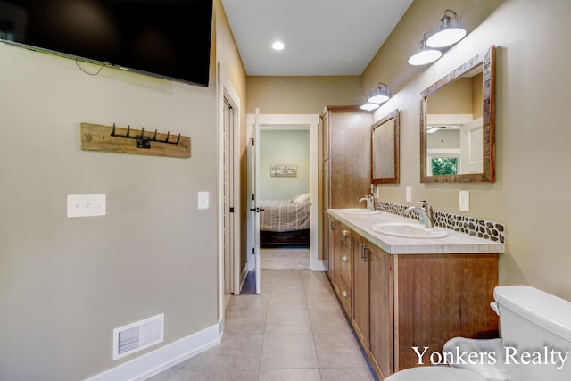 1109 Kenowa Ave SW, Byron Center, MI 49315 - ensuite bathroom featuring double vanity, tile patterned floors, toilet, and baseboards