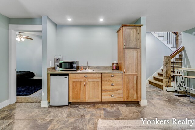 1109 Kenowa Ave SW, Byron Center, MI 49315 - kitchen featuring stainless steel microwave, baseboards, a sink, a ceiling fan, and light countertops