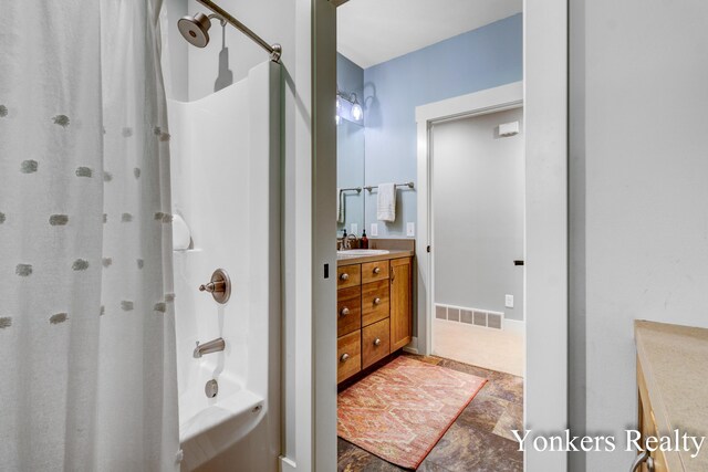 1109 Kenowa Ave SW, Byron Center, MI 49315 - full bath with vanity, stone finish floors, and shower / bath combo