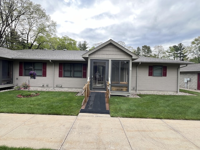 5764 W Brookwood Pl, Ludington, MI 49431 - ranch-style house featuring a front yard and a shingled roof