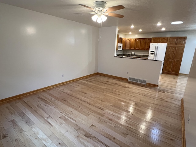 5764 W Brookwood Pl, Ludington, MI 49431 - unfurnished living room featuring light wood-style flooring, ceiling fan, recessed lighting, baseboards, and a sink