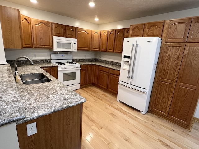 5764 W Brookwood Pl, Ludington, MI 49431 - kitchen with white appliances, a sink, brown cabinets, light wood finished floors, and recessed lighting