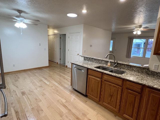 5764 W Brookwood Pl, Ludington, MI 49431 - kitchen with dishwasher, a ceiling fan, a sink, brown cabinetry, and a textured ceiling