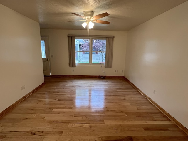5764 W Brookwood Pl, Ludington, MI 49431 - empty room with ceiling fan, light wood-style flooring, a textured ceiling, and baseboards