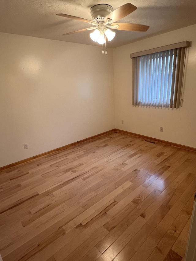 5764 W Brookwood Pl, Ludington, MI 49431 - unfurnished room featuring a ceiling fan, light wood finished floors, baseboards, and a textured ceiling