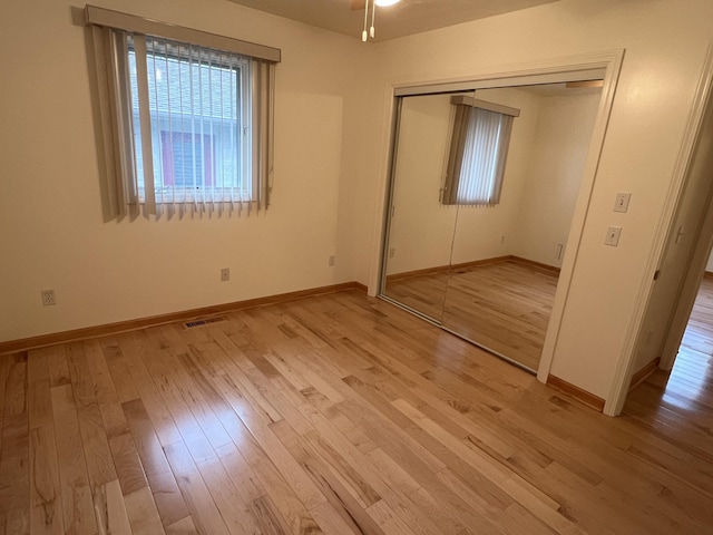 5764 W Brookwood Pl, Ludington, MI 49431 - unfurnished bedroom featuring light wood finished floors, a closet, and baseboards