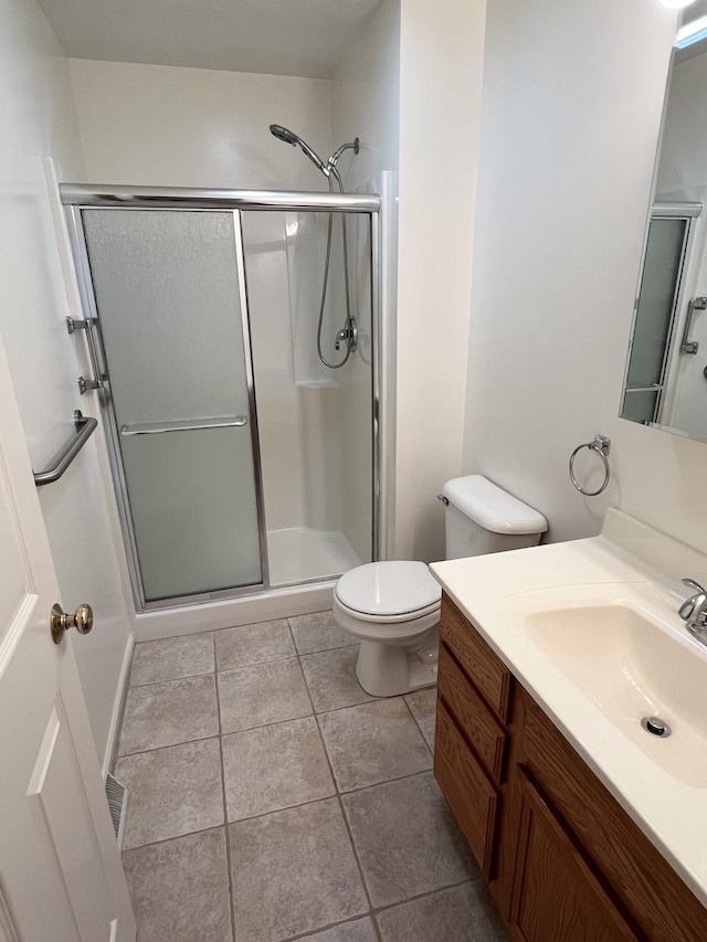 5764 W Brookwood Pl, Ludington, MI 49431 - full bath featuring vanity, a stall shower, toilet, and tile patterned flooring