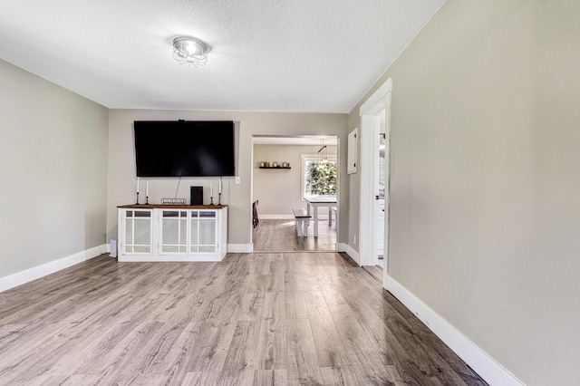 4371 N 68th Ave, Hart, MI 49420 - unfurnished living room with wood finished floors, a textured ceiling, and baseboards