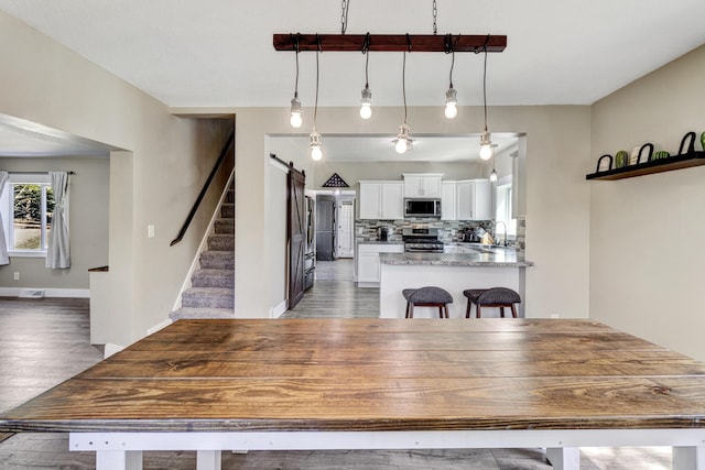 4371 N 68th Ave, Hart, MI 49420 - dining room featuring light wood-style floors, baseboards, and stairway