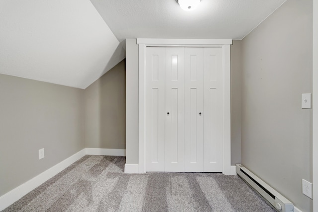 4371 N 68th Ave, Hart, MI 49420 - unfurnished bedroom featuring a baseboard radiator, carpet flooring, a closet, baseboards, and lofted ceiling