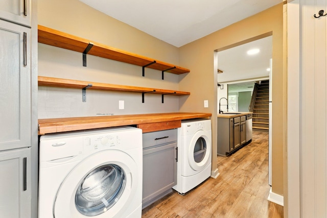 8075 Burlingame Ave SW, Byron Center, MI 49315 - laundry room with cabinet space, washer and dryer, and light wood-style flooring