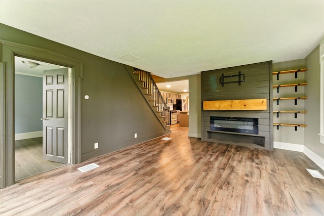 8075 Burlingame Ave SW, Byron Center, MI 49315 - unfurnished living room with wood finished floors, baseboards, and stairway