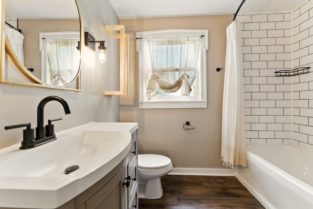 8075 Burlingame Ave SW, Byron Center, MI 49315 - full bathroom featuring vanity, toilet, shower / bathtub combination with curtain, wood finished floors, and baseboards