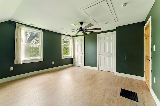 8075 Burlingame Ave SW, Byron Center, MI 49315 - unfurnished bedroom featuring attic access, light wood-style flooring, baseboards, ceiling fan, and lofted ceiling