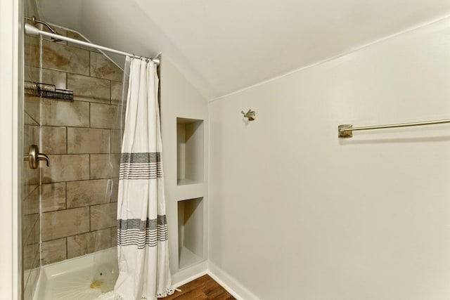 8075 Burlingame Ave SW, Byron Center, MI 49315 - full bath featuring tiled shower, lofted ceiling, baseboards, and wood finished floors