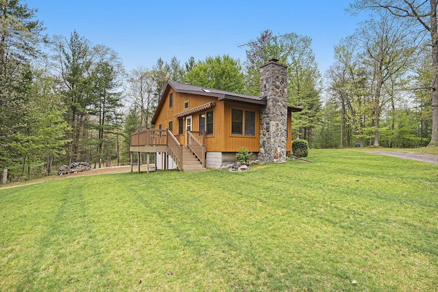 4900 N Railroad Ave, Pentwater, MI 49449 - view of side of home with a chimney, driveway, a lawn, a deck, and an attached garage