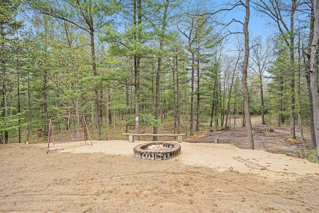 4900 N Railroad Ave, Pentwater, MI 49449 - view of yard with a fire pit and a wooded view