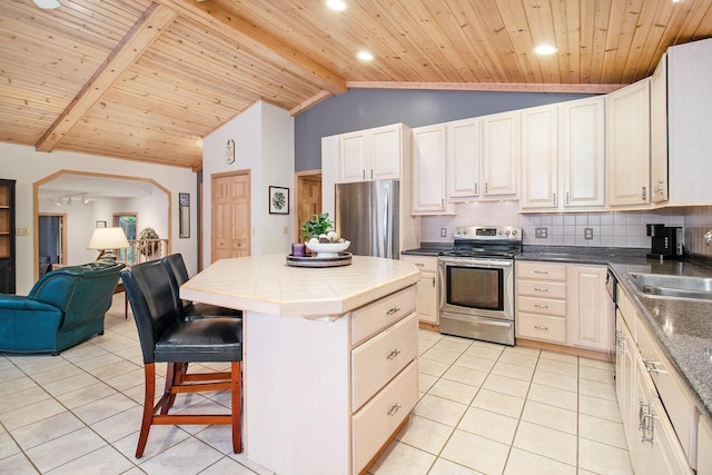 6818 W Vesper Dr, Ludington, MI 49431 - kitchen featuring stainless steel appliances, a sink, wood ceiling, tile counters, and decorative backsplash