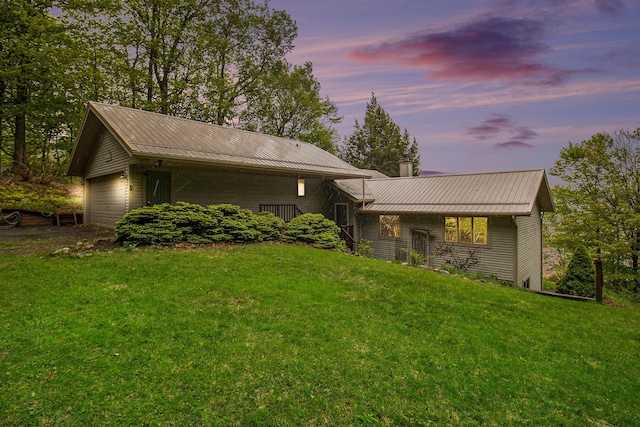 6818 W Vesper Dr, Ludington, MI 49431 - view of front of home featuring metal roof, a front lawn, a garage, and a chimney
