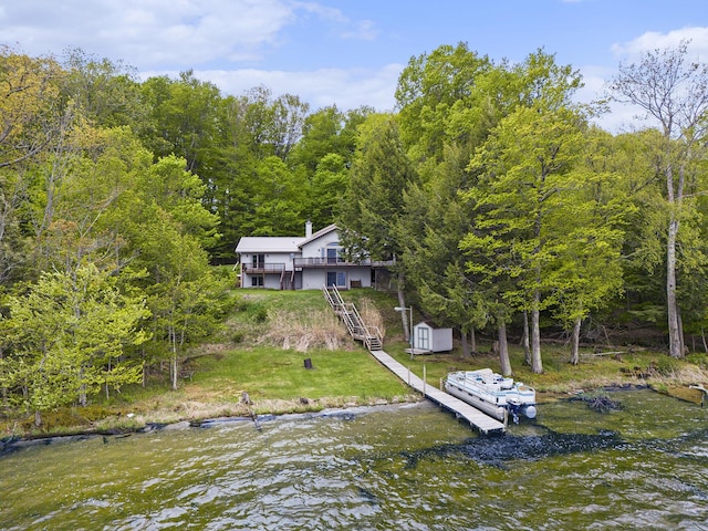 6818 W Vesper Dr, Ludington, MI 49431 - dock area featuring stairway, a view of trees, a lawn, and a water view