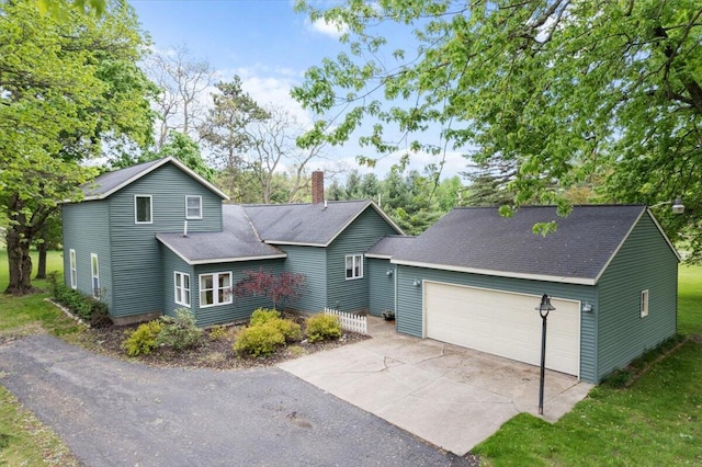 11087 Phelps Ave NW, Sparta, MI 49345 - view of front of home featuring a chimney, a garage, driveway, and roof with shingles