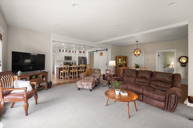 11087 Phelps Ave NW, Sparta, MI 49345 - living area featuring a barn door, light colored carpet, and a chandelier