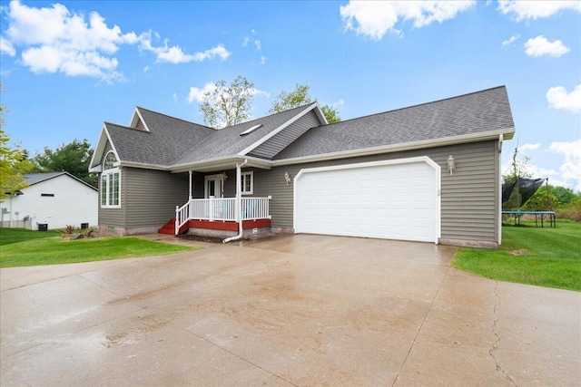 306 Meister Rd, Fremont, MI 49412 - view of front of property featuring a trampoline, driveway, a front yard, a garage, and a shingled roof