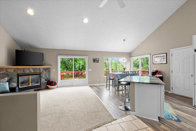 306 Meister Rd, Fremont, MI 49412 - kitchen with a fireplace, a center island, light wood finished floors, ceiling fan, and baseboards