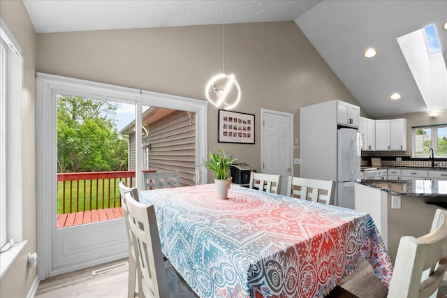 306 Meister Rd, Fremont, MI 49412 - dining room with a skylight, light wood finished floors, high vaulted ceiling, and recessed lighting