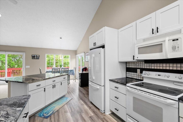 306 Meister Rd, Fremont, MI 49412 - kitchen featuring white appliances, light wood finished floors, lofted ceiling, white cabinetry, and dark stone counters