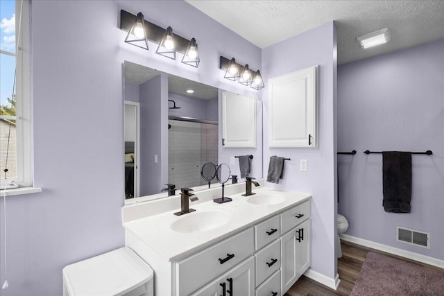 306 Meister Rd, Fremont, MI 49412 - bathroom featuring toilet, a shower stall, double vanity, wood finished floors, and baseboards