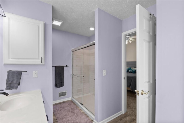 306 Meister Rd, Fremont, MI 49412 - bathroom with ensuite bath, a stall shower, baseboards, a textured ceiling, and ceiling fan
