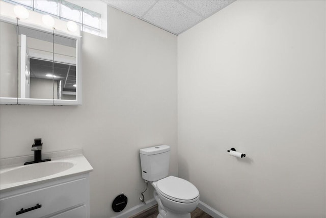 306 Meister Rd, Fremont, MI 49412 - bathroom with vanity, toilet, baseboards, and a paneled ceiling