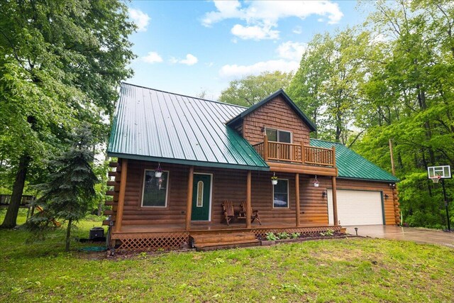 65 N Brown Rd, Bailey, MI 49303 - log home featuring a porch, concrete driveway, metal roof, a garage, and a front yard