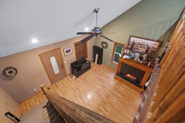 65 N Brown Rd, Bailey, MI 49303 - living room with ceiling fan, wood finished floors, a glass covered fireplace, vaulted ceiling, and a textured ceiling